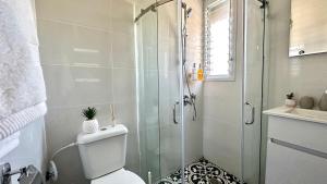 a bathroom with a shower and a toilet and a sink at Beautyful Resort Apartment in Haifa +24 photos