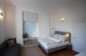 a white room with a bed and a window at theMAP in Lenzkirch