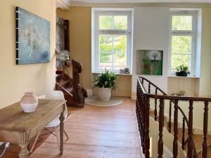a living room with a wooden table and stairs at theMAP in Lenzkirch