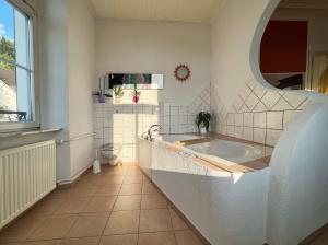 a large bathroom with a tub and a window at theMAP in Lenzkirch +64 photos