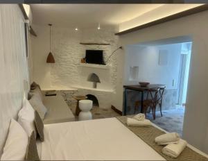 a bedroom with a bed and a living room with a fireplace at Kampisma Project 2 in Dhriopís