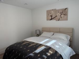 a bedroom with a large bed with two pictures on the wall at Calm & Cozy Private Suite in Surrey