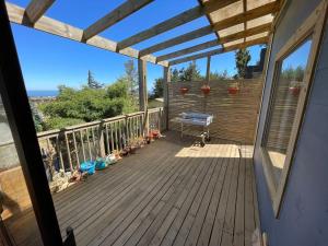 a deck with a bench and plants on it at casa del barco 1 in Pichilemu