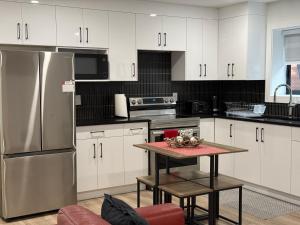 a kitchen with white cabinets and a stainless steel refrigerator at Calm & Cozy Private Suite in Surrey +14 photos