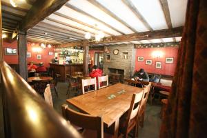 a restaurant with a wooden table and people sitting at tables at Three Shires Inn in Little Langdale