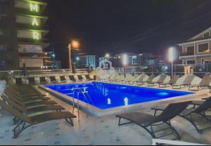 a swimming pool at night with chairs around it at Mira apartament by Alezzi n10 in Mamaia Nord