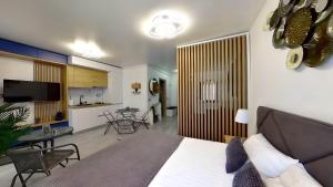 a bedroom with a bed and a living room and a kitchen at Mira apartament by Alezzi n10 in Mamaia Nord