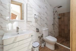 Un baño blanco con inodoro y lavabo. en Gudauri Star, en Gudauri 26 fotos más