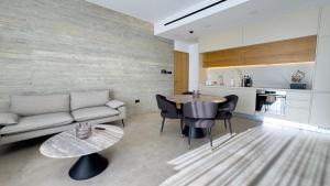 a living room with a couch and a table at Malberry Park 303 - Modern 2bedroom Apt with Shared Heated Pool, Sauna, Gym, Jacuzzi in Paphos City