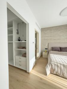 a bedroom with a large bed and white walls at Malberry Park 303 - Modern 2bedroom Apt with Shared Heated Pool, Sauna, Gym, Jacuzzi in Paphos City