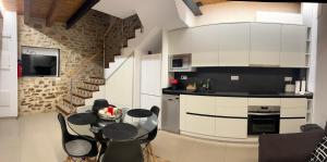una cucina con mobili bianchi, tavolo e sedie di CASA LA ABUELA a Olocau del Rey