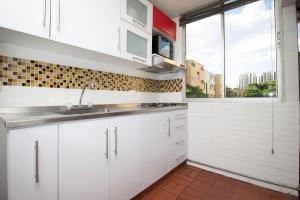 カリにあるApartamento Cali Camino Realのシンクと窓のある白いキッチン +8枚の写真
