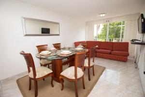 カリにあるApartamento Cali Camino Realのテーブルと椅子とソファのあるダイニングルーム