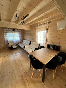 a living room with a table and a couch at Fuledzki domek letniskowy in Fuleda