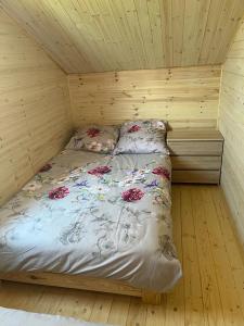 a bedroom with a bed in a wooden room at Fuledzki domek letniskowy in Fuleda