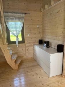 a room with a wooden wall with a window at Fuledzki domek letniskowy in Fuleda