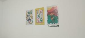 a group of three posters on a wall at Casa do Léo 1- México e África- Apartamento completo perto das praias do litoral sul , Ar condicionado ,Wi-Fi, garagem, churrasqueira e pet friendly in João Pessoa