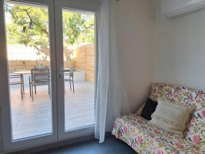 ein Raum mit einer Glasschiebetür, die zu einer Terrasse führt in der Unterkunft Appart Béziers - Campagne de Montimas in Béziers