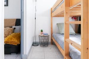 a small room with a bunk bed and a couch at Appartement Quartier les Presidents - 2-4 personnes in La Rudelière