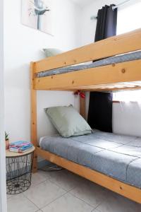 a bunk bed in a room next to a table at Appartement Quartier les Presidents - 2-4 personnes in La Rudelière