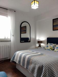 a bedroom with a bed and a mirror on the wall at Doña Carmen Playa Boutique in Suances