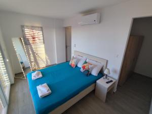 a bedroom with a blue bed with pillows at Blauer Horizont in Povljana +32 photos