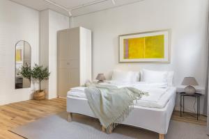 a bedroom with a white bed with a blanket on it at Scandi Style Stockholm Apartment in Stockholm