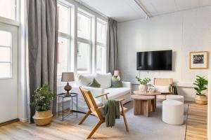 a living room with a white couch and a tv at Scandi Style Stockholm Apartment in Stockholm