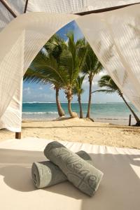 a view of a beach with palm trees and an umbrella at Ocean Blue & Sand Beach Resort - All Inclusive in Punta Cana +105 photos