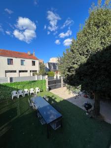 a backyard with a table and chairs and a grill at VR House 14 bedrooms 3 min metro 23 beds PARC EXPO in Bagneux