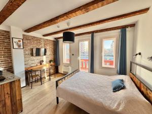 a bedroom with a bed and a kitchen with a table at Apartment By the River in Niš