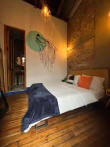 a bedroom with a bed and a wall with a painting at Socialtel Candelaria Bogotá in Bogotá