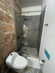 a bathroom with a white toilet and a shower at Socialtel Candelaria Bogotá in Bogotá
