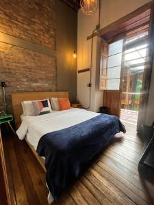 a bedroom with a bed and a brick wall at Socialtel Candelaria Bogotá in Bogotá