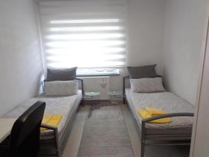 two beds in a small room with a window at Appartments Yalcin Hannover Laatzen Nähe Messe in Hannover