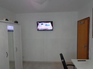 a tv on a wall in a room with a table at Appartments Yalcin Hannover Laatzen Nähe Messe in Hannover