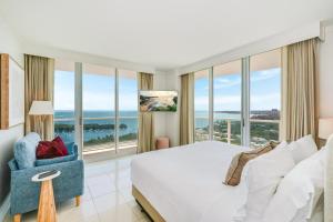 a bedroom with a bed and a chair and windows at Bay View Beauty 1 Bedroom condo in Coconut Grove Parking Included in Miami +56 photos