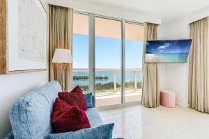 a living room with a blue couch and a large window at Bay View Beauty 1 Bedroom condo in Coconut Grove Parking Included in Miami