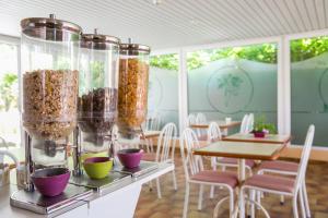 een kamer met tafels en stoelen met voedsel in glazen containers bij Bel Ombra Hôtel in Bandol