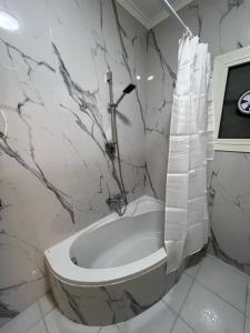 a bathroom with a bath tub with a shower curtain at فيلا في مدينتي in Madinaty +29 photos