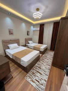 a bedroom with two beds and a rug at فيلا في مدينتي in Madinaty