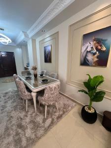 a dining room with a table and chairs and a painting at فيلا في مدينتي in Madinaty