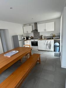 a kitchen with white cabinets and a wooden table at Maison de bourg in Les Épesses