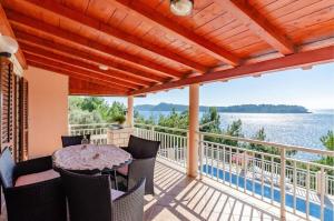 a balcony with a table and chairs and a view of the water at House Vila Petra in Blato