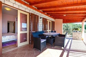 a patio with a table and chairs on a porch at House Vila Petra in Blato