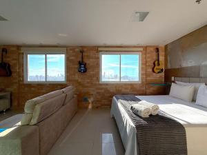 a bedroom with a bed and a couch and windows at iFlat brookfield Towers BTLX2817 Jardim Goiás in Goiânia +25 photos