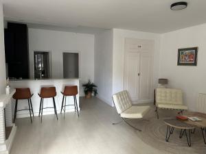 Una sala de estar con sillas, una mesa y un mostrador. en Apartment in Malaga 8 mins from the Beach, en Málaga