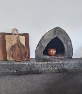 einen Steinofen mit einem Schneidebrett und einer Schale in der Unterkunft Casa and Company - Azorean Boutique House in Santa Cruz da Graciosa