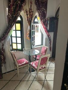 comedor con mesa de cristal y 2 sillas en Room 3 Riad Khadija With Breakfast, en Rabat