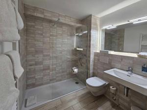 un bagno con doccia, WC e lavandino di Badehotel Salina Maris – Wellness & Vintage a Mörel